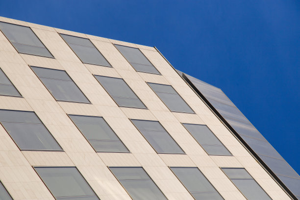 在一个阳光灿烂的日子里，一座建筑与蓝天的抽象画。图片下载