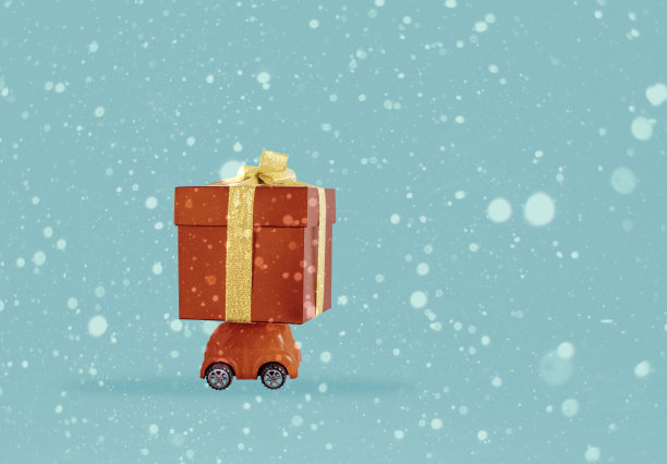 圣诞概念，红色的小车在雪下运送礼物，蓝色的背景图片下载