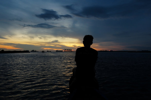 一个男人坐在船头的剪影图片下载