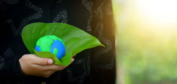 世界地球日。ESG的环保理念，环境和生态关怀。手握绿色地球仪。图片下载