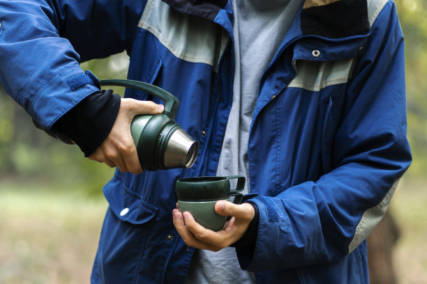 游客从保温瓶里倒热水图片下载