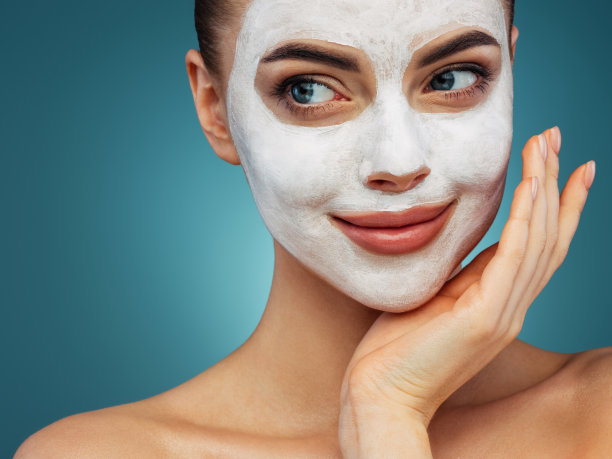 快乐的年轻女孩脸上敷着面膜图片下载