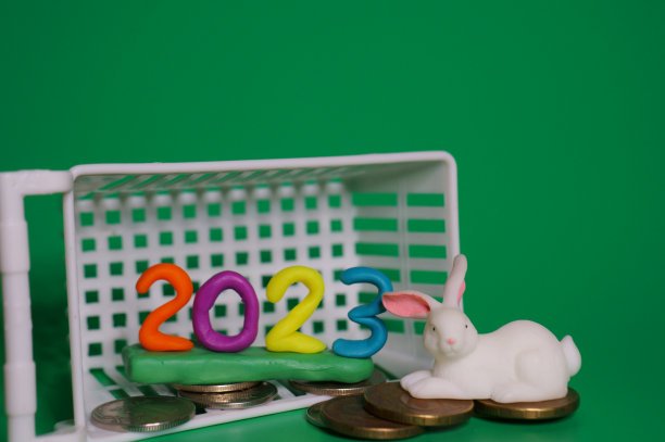 绿色背景的兔子雕像，上面有硬币和篮子。图片下载