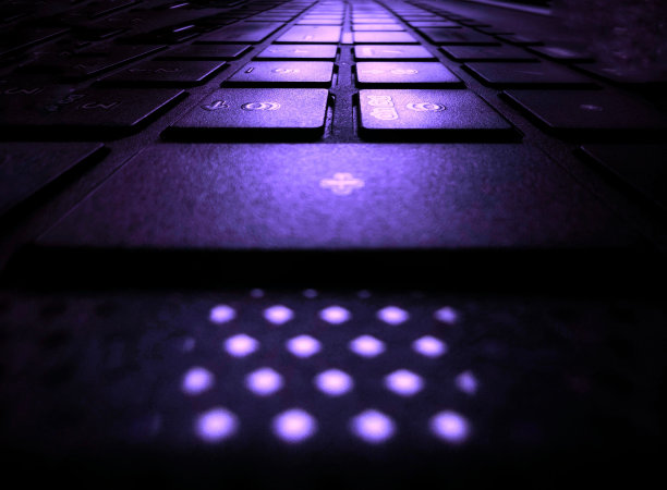 用紫色照明的电脑键盘特写镜头图片下载