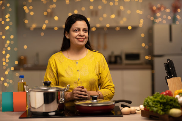 印度妇女在厨房做饭时享受的画像。库存图片图片下载