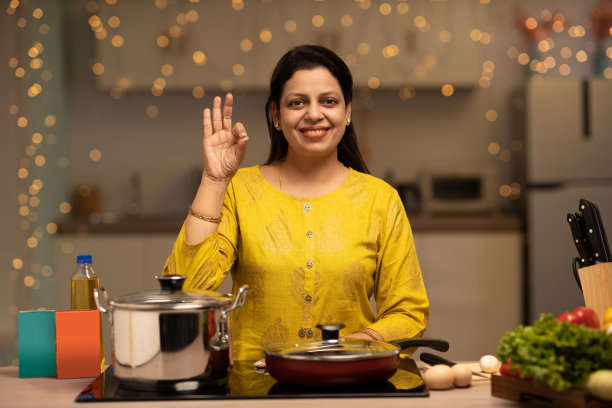印度妇女在厨房做饭时享受的画像。库存图片图片下载