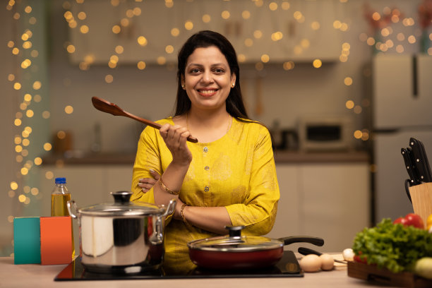 印度妇女在厨房做饭时享受的画像。库存图片图片下载