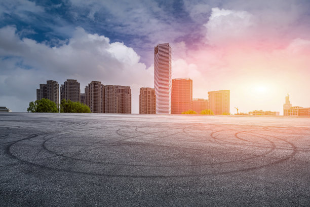 夕阳下的柏油跑道和城市建筑图片下载