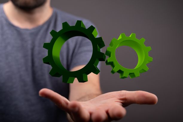 3D渲染汽车齿轮系统在人的手中盘旋图片下载