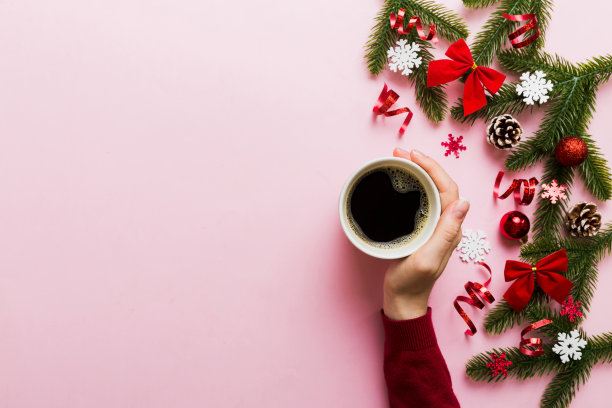 拿着咖啡的女人。女人的手拿着一杯热咖啡。冬季和圣诞节的时间概念图片下载