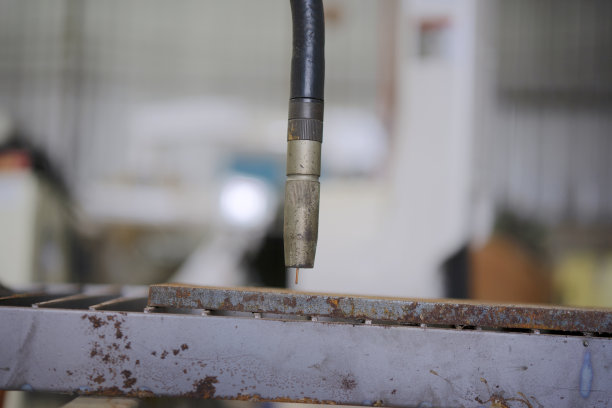 蓝领工人正在用焊接机械臂工作。图片下载