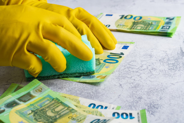 洗钱。戴黄手套的人用绿色毛巾洗100欧元的纸图片下载
