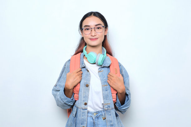 微笑着年轻漂亮的女人背着背包回到学校孤立的白色背景图片下载