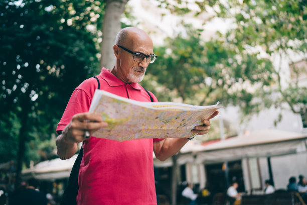 迷路的男旅行者在街上看地图图片下载