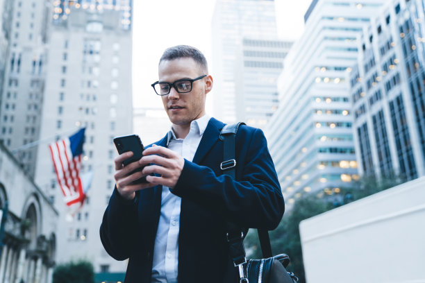 戴眼镜的英俊商人在市中心打电话发短信图片下载