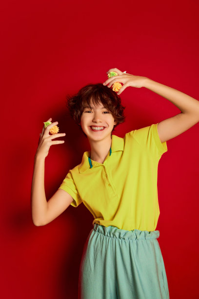 肖像快乐的少女卷曲的棕色短发与棉花糖孤立在红色背景摆姿势。糖果的情人图片下载