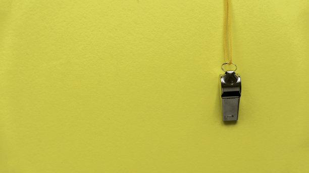 哨子挂在黄色的墙上。图片下载