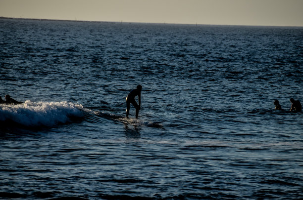 夕阳下的剪影冲浪者图片下载