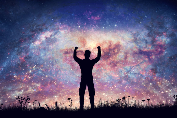 幸福的人，双手高举在夜空的星云和星星图片下载