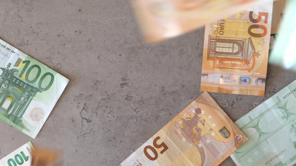 欧元钞票掉在桌子上。现金100欧元和50欧元纸币从上面掉下来图片下载