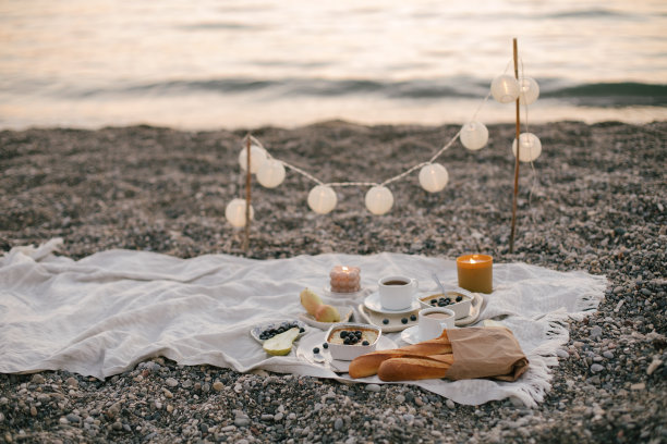 日落时分的海边浪漫野餐。图片下载