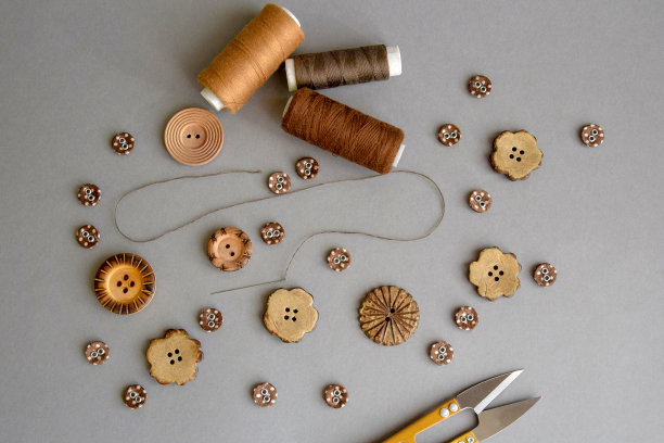 缝纫和针线活配件:钮扣、剪刀、带线针、一套线卷、顶视图、平铺。图片下载
