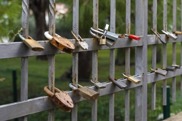 许多金属锁的特写，情侣们挂在金属栅栏上。一对相爱的情侣在旅途中。爱锁。图片下载