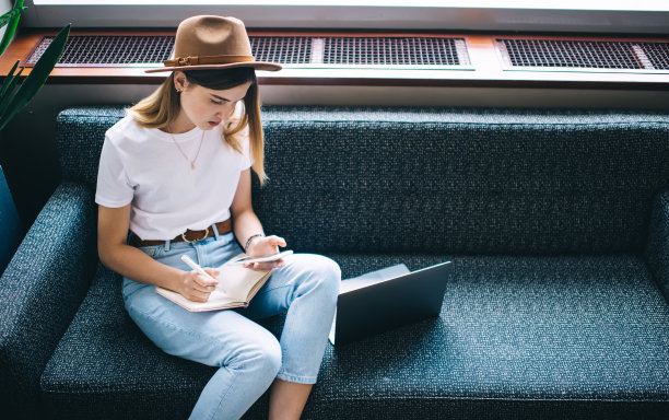 时尚女企业家使用智能手机，在日记中做笔记图片下载