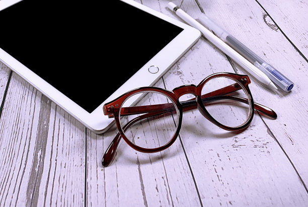 在白色木制背景上的数字平板电脑模型。白色木桌上的电子平板。图片下载