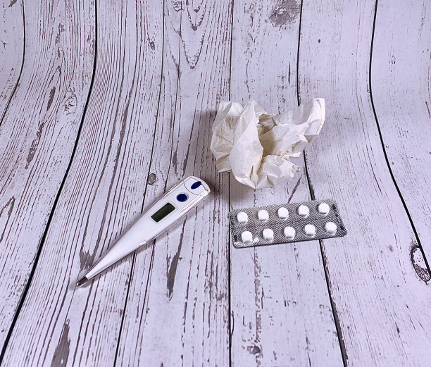 感冒和流感季节的墙纸。温度计、纸巾和药片放在浅色的木质背景上。病毒的治疗和预防。图片下载