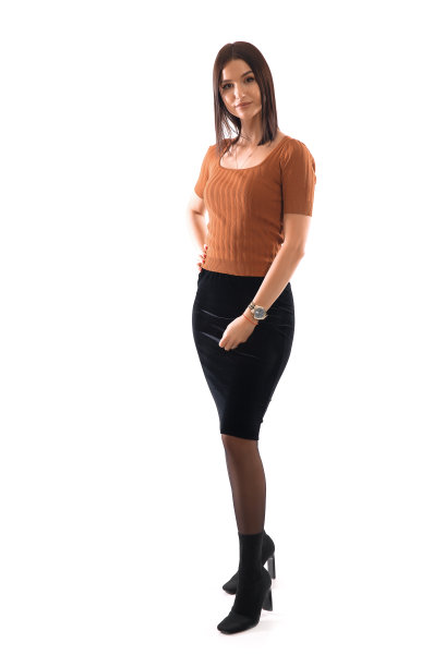美丽的商务女士在橙色衬衫和黑色裙子摆姿势在白色背景前图片下载