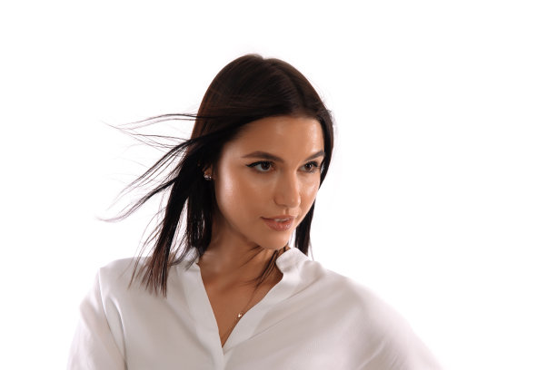 在白色背景前，穿着白衬衫的迷人女子摆出了姿势图片下载