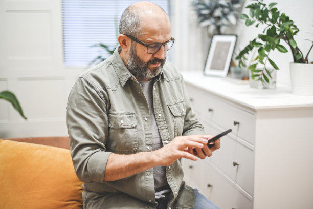 在家庭办公室工作的商人(笔记本电脑，手机)图片下载