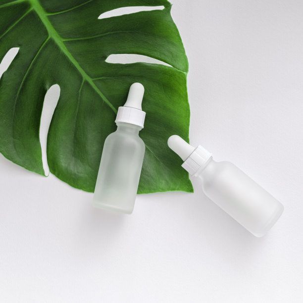 哑光瓶与怪物叶在白色背景。SPA天然有机化妆品。带移液管的玻璃化妆品瓶，胶原蛋白和多肽，化妆品模型，护肤概念图片下载