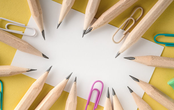 白色的床单铺在黄色的底色上。印有彩色回形针和铅笔的名片。用来做注释和说明的白纸。教育观念空白，文本有复制空间图片下载