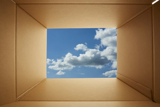 透过纸板箱向蓝色的天空背景看。图片下载