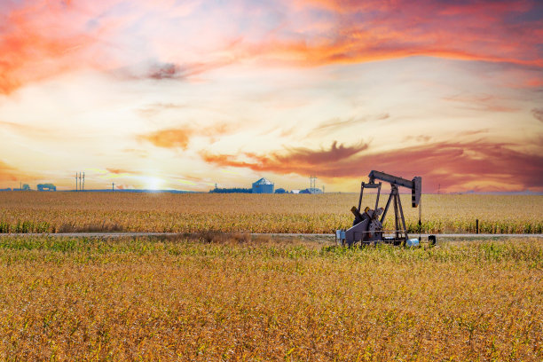 广角拍摄的油泵千斤顶在堪萨斯与美丽的日落背景图片下载