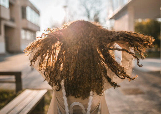 不认识的卷头发女人享受日落图片下载