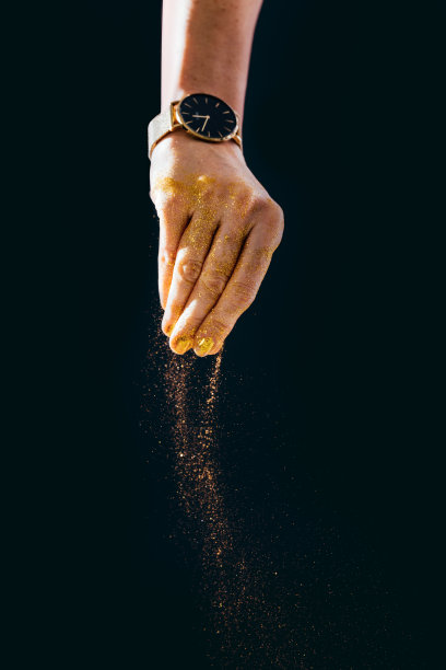 特写照片的女人手玩金色的闪光图片下载