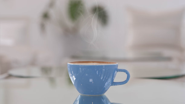 咖啡馆的桌子上放着蓝色的艺术拿铁。在杯子上放泡沫花。小勺子和盘子。合上桌上的咖啡杯。图片下载