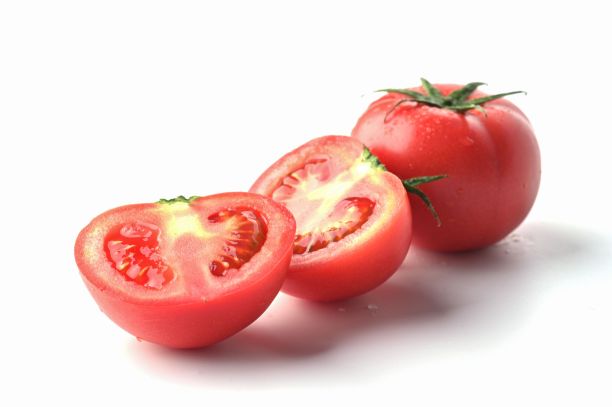特写侧面拍摄的两个西红柿，一个在白色背景上切片图片下载