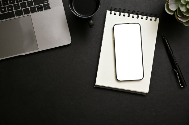 现代黑色办公桌工作空间顶视图与智能手机模型，螺旋记事本，笔记本电脑图片下载