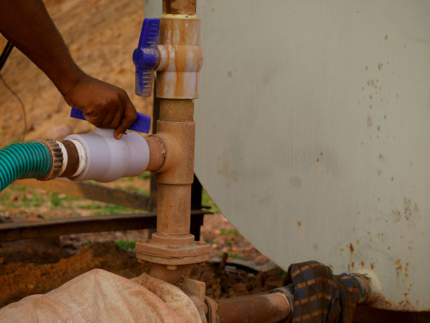亚洲男性技术员在施工现场操作水管调节器。图片下载