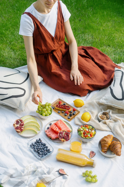 小女孩在后院的草地上吃早餐，吃糖果和水果图片下载