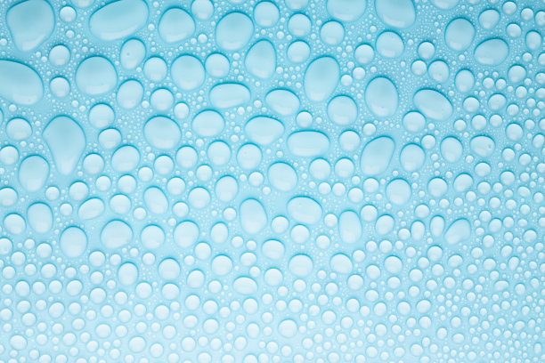 水滴在冷柔和的浅蓝色背景作为图案的不同的圆形有光泽的闪光滴露珠与梯度，纹理，顶视图。图片下载