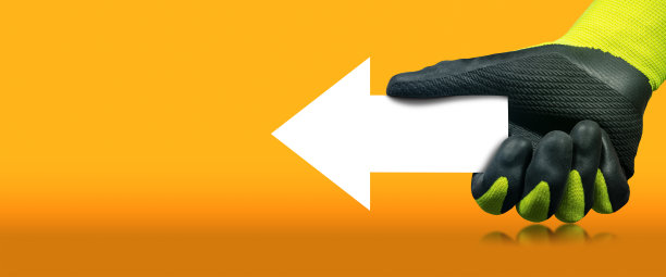戴手套的手拿着橙色背景上的白色方向标志图片下载