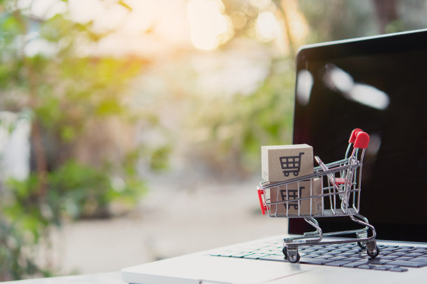 网上购物。笔记本电脑键盘上有一个购物车标志的纸板箱。网上购物服务。提供送货上门服务图片下载
