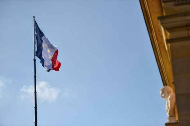 旗杆上的法国和欧盟旗帜随风飘扬。背景是蓝天图片下载