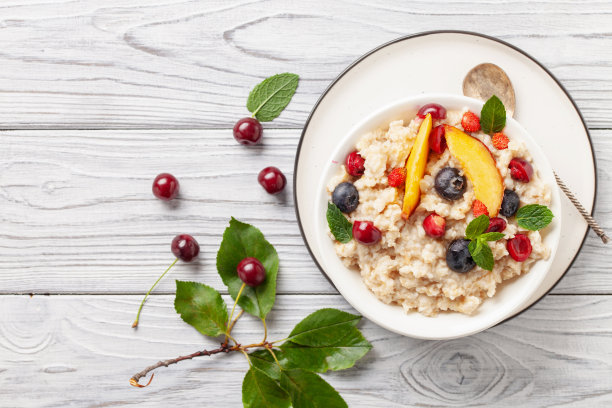 桌上的碗里盛着浆果燕麦粥。健康的早餐。婴儿食品。图片下载