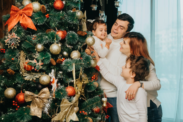 家里的妈妈，爸爸，弟弟和妹妹正在装饰圣诞树。图片下载